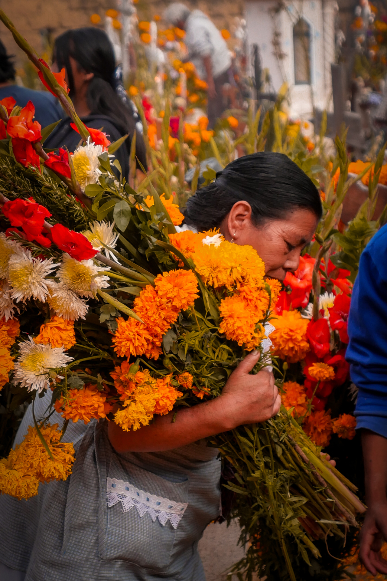 Mujer con cempasúchiles durante Día de Muertos en México