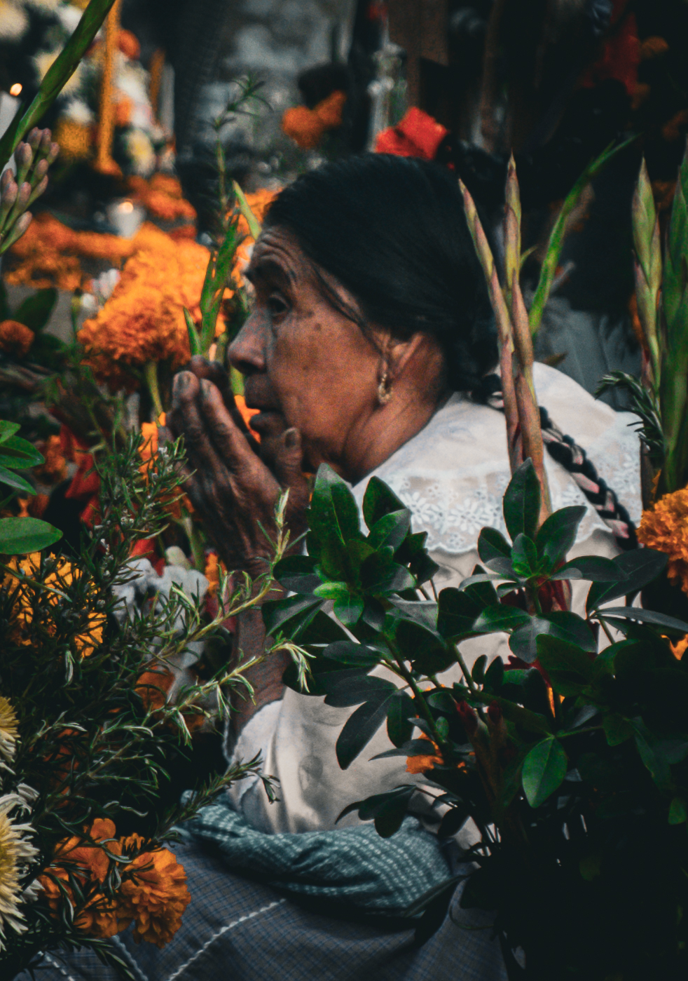 Mujer rezando en un altar iluminado por velas